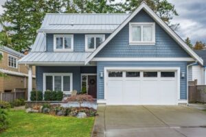 a quaint cottage-style home with a white garage door with windows